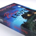 Titel: "Böse Leute". Schrift oben: "Dora Heldt". Ein illustriertes Haus und Leuchtturm bei Nacht.