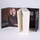 Ein aufgeschlagenes Buch mit einem Mann im braunen Mantel auf dem Umschlag. Text von Jens Henrik Jensen.