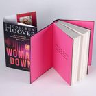 Zwei Bücher, eines offen, das andere mit Covertext "COLLEEN HOOVER", "WOMAN DOWN", "Er soll sie retten...", rosa Innenseiten.