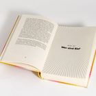 Offenes Buch, rechts steht: "Erster Teil Wer sind Sie?" mit strahlenförmigem Hintergrundmuster. Links ist Text mit Seitenzahl 28.