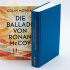 Text: "Die Ballade von Ronan McCoy" von Colin Morgan. Buch mit blauem Einband, daneben ein Umschlag mit farbigem Design.