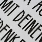 "MIT DEINEN BEDENKEN" ist in dicken schwarzen Buchstaben auf einem weißen Hintergrund zu sehen.