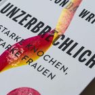 Buchcover mit Text: „Unzerbrechlich. Starke Knochen, starke Frauen.“ Farbige Spirale ziert das Cover.