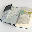 Ein Buch ist aufgeschlagen, darin eine Karte mit Ländern wie Afghanistan, Pakistan, Indien und China.