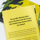 Text auf gelbem Hintergrund: "Ein großer Roman über einen Gasthof und die Frage: Wie findet man innere Ruhe im Leben?"