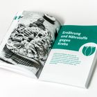 „Ernährung und Nährstoffe gegen Krebs“ steht auf einer Buchseite mit einer Fotografie von Speisen links daneben.