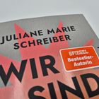 Text: "Juliane Marie Schreiber", "WIR SIND", "SPIEGEL Bestseller-Autorin", "PIPER". Hintergrund rot-grau, Titel hervorgehoben.