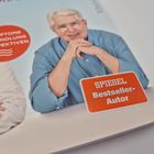 Text "SYMPTOME BEHANDLUNG PERSPEKTIVEN" in rotem Kreis, "SPIEGEL Bestseller-Autor" im weißen Rahmen. Mann lächelt.