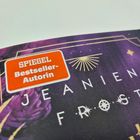 "SPIEGEL Bestseller-Autorin" steht in einem orangefarbenen Etikett. Darunter violette Blumen auf dunklem Hintergrund.