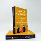 Der Titel des Buches lautet: "SALLY ROONEY GESPRÄCHE MIT FREUNDEN". Es ist ein Roman mit einem gelben Cover.