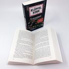 Text: "KLÜPFEL KOBR Erntedank Kriminalroman". Ein geschlossenes Buch steht hinter einem aufgeschlagenen Buch.