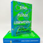 „Sind Flüsse Lebewesen?“, Robert Macfarlane. Lebhaftes grünes, blaues Wellenmuster, zwei Bücher übereinander.