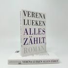 "VERENA LUEKEN ALLES ZÄHLT ROMAN" auf einem Buch. Es liegt ein weiteres Exemplar darunter mit "ullstein" am Rücken.