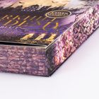 "Cover leuchtet im Dunkeln." Text in Gold auf lila Hintergrund mit abstraktem Muster neben einer Burgsilhouette und Kerzen.