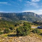 Text: "Mit seinen unzähligen, auf 725 Meter hinauf windenden Kurven entpuppt sich der Col de l'Espigoulier als Trasse der Extraklasse." Ein blauer Oldtimer steht auf einer kurvigen Straße in einer bergigen Landschaft.