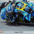 Kalenderseite zeigt August 2027. Ein Motorradfahrer in blauer Rennkleidung lehnt sich in eine Kurve.