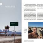 "Etappe 4: AMBOY – NEEDLES". Foto: Zwei Männer mit Getränken, lächelnd. Straßenschild: „AMBOY“. Geschäft: „ROY'S CAFE“.