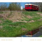 "Niedersachsen", "Der historische Triebwagen DT 511 der AVL am 23. April 2023...", rote Bahn auf Bahndamm, reflektiert im Wasser.