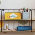 "MEIN MORGEN" in einer Sprechblase auf gelbem Tischkalender, daneben ein Huhn. Stifte in einem gestreiften Becher.