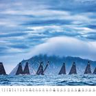 Kalenderblatt mit April-Kalendarium. Segelboote auf dem Meer, bewölkter Himmel, Berg im Hintergrund.