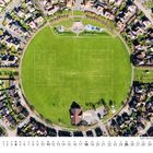 Kalender für April, darunter eine Luftaufnahme eines kreisförmigen Parks mit zwei markierten Fußballfeldern, umgeben von Häusern.