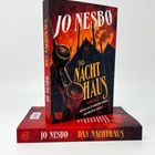 "Jo Nesbø, Das Nachthaus", Großstadt-Hintergrund mit rotem Himmel, altes Telefon im Vordergrund.