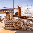 „Aufbruch: ‚Ein Schiff im Hafen ist sicher, doch dafür werden Schiffe nicht gebaut.‘ John Augustus Shedd.” Seil auf Poller.