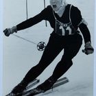 Nummer 11. Eine Person in Skikleidung fährt dynamisch Ski, mit entschlossenem Gesichtsausdruck.