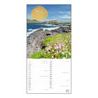Zitat über Ruhezeit und Ort. Küstenlandschaft mit Felsen, Blumenwiese und Meer im Hintergrund. Kalender für Mai.