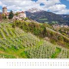 Aprilkalender mit altem Schloss und blühenden Plantagen vor schneebedeckten Bergen unter blauem Himmel.