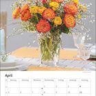 Aprilkalender mit einem Foto eines bunten Blumenstraußes in einer Vase auf einem Tisch.