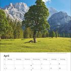 Aprilkalender mit Tagen in Spalten. Oben ein Baum auf einer Wiese vor Bergkulisse und blauem Himmel.