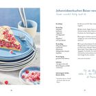 Johannisbeerkuchen Baiser Version Rezept. Links ein Kuchenstück auf blauen Tellern, daneben rote Johannisbeeren.
