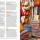Links informativer Text über Feste und Einkaufen in Marrakesch. Rechts bunte Taschen, Kissen und Stoffe in einem Geschäft.