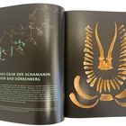 „Das Grab der Schamanin von Bad Dürrenberg“ steht neben einem archäologischen Skelettarrangement auf zwei Buchseiten.