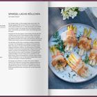 Titel: SPARGEL-LACHS-RÖLLCHEN. Rezepttext links; rechts ein Teller mit gerollten Spargel-Lachs-Päckchen, dekoriert mit Dill.