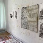 Zahl 196 unten links. Verschiedene abstrakte Kunstwerke an einer Wand, rechts Vorhänge am Fenster.