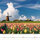 Kalenderblatt für April 2023, Zahlen in Rot und Schwarz. Tulpenfeld mit Windmühle vor blauem Himmel und weißen Wolken.