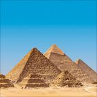 Keine Texte. Drei große Pyramiden in einer Wüstenlandschaft unter klarem blauem Himmel.