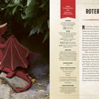 "ROTER DRACHE" in großer Schrift, ein gehäkelter Drache sitzt in einem grünen Garten auf Felsen.
