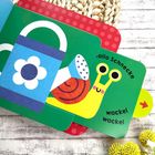 "Hallo Schnecke wackel wackel" auf einem bunten Buch mit Gießkanne und fröhlicher Schnecke. Texturen, helle Farben.