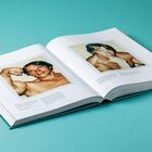 Eine Zeitschrift zeigt zwei Fotos eines muskulösen Mannes, oben ohne, mit kurzen Bildunterschriften auf einer hellblauen Oberfläche.