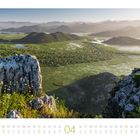 Kalender: April, mit einem Panoramablick auf eine grüne Landschaft und Berge im Hintergrund.