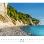 Kreidefelsen, Nationalpark Jasmund, Insel Rügen. Kalenderblatt April, Küste mit weißem Kliff und blauem Meer unter klarem Himmel.