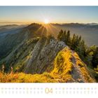 Aprilkalender mit Bergpfad und Sonnenaufgang über bewaldeten Hügeln.