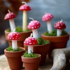 Keine Texte vorhanden. Mehrere Kerzen in Form von Fliegenpilzen in kleinen Tontöpfen auf Moos.