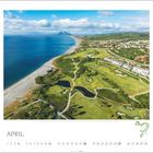 "April" und eine Monatsansicht, küstennaher Golfplatz mit gepflegten Rasenflächen und Gebäuden im Hintergrund.