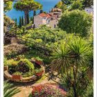 Kalenderseite für April; oben mediterrane Landschaft mit Küstenblick, Bäumen, Gebäuden und bunten Blumen.