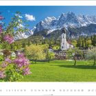 Kalender mit Datumsauswahl, Landschaft mit Kirche vor schneebedeckten Bergen, Wiese und blühenden Bäumen im Vordergrund.