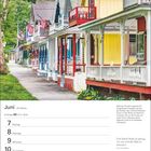 Juni, 23. Woche, Zwillinge: 21.5. - 20.6. Kalenderwoche mit schönen, bunten Holzhäusern, umgeben von grünen Bäumen.